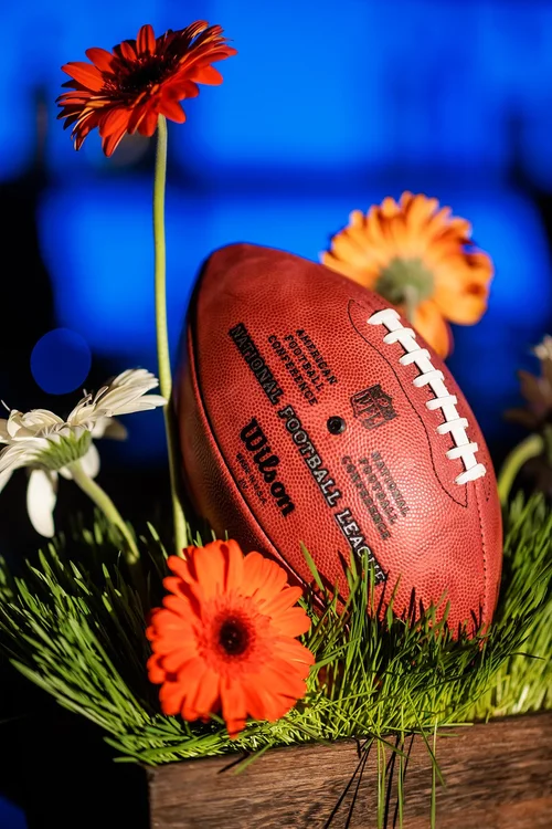 Denver Broncos football centerpiece with orange flowers and Wilson NFL ball event detail photography