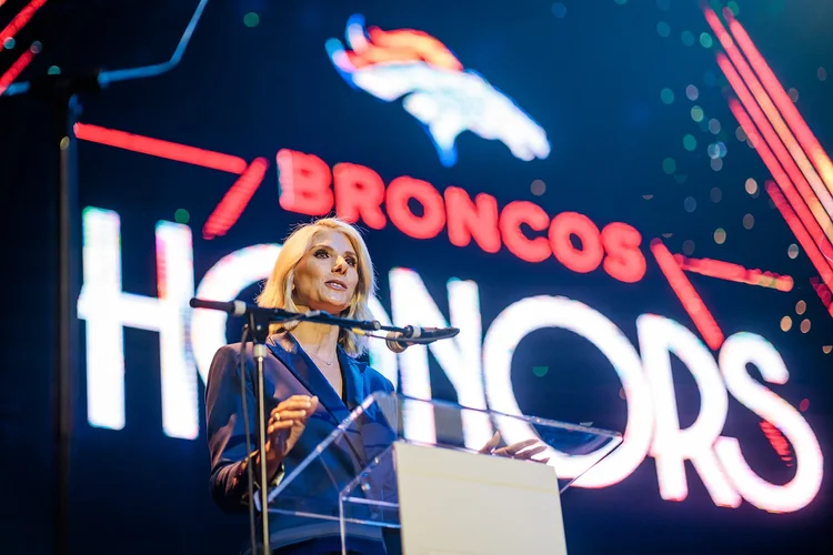 Host at podium with Broncos Honors LED backdrop and Broncos logo Mission Ballroom Denver