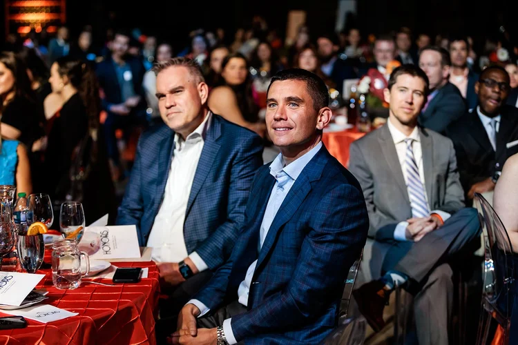 Guests at table watching the program at Denver Broncos Honors Awards Mission Ballroom Denver