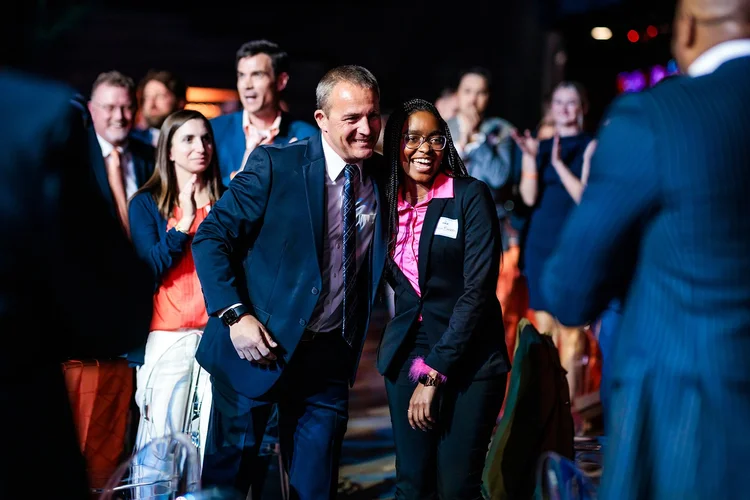 Award honoree walking aisle with escort at Broncos Honors Awards event Denver Colorado