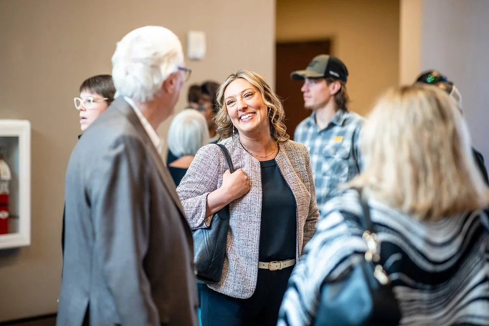 Woman smiling in conversation at arrival for Community College of Aurora Annual Luncheon Hyatt Regency Denver