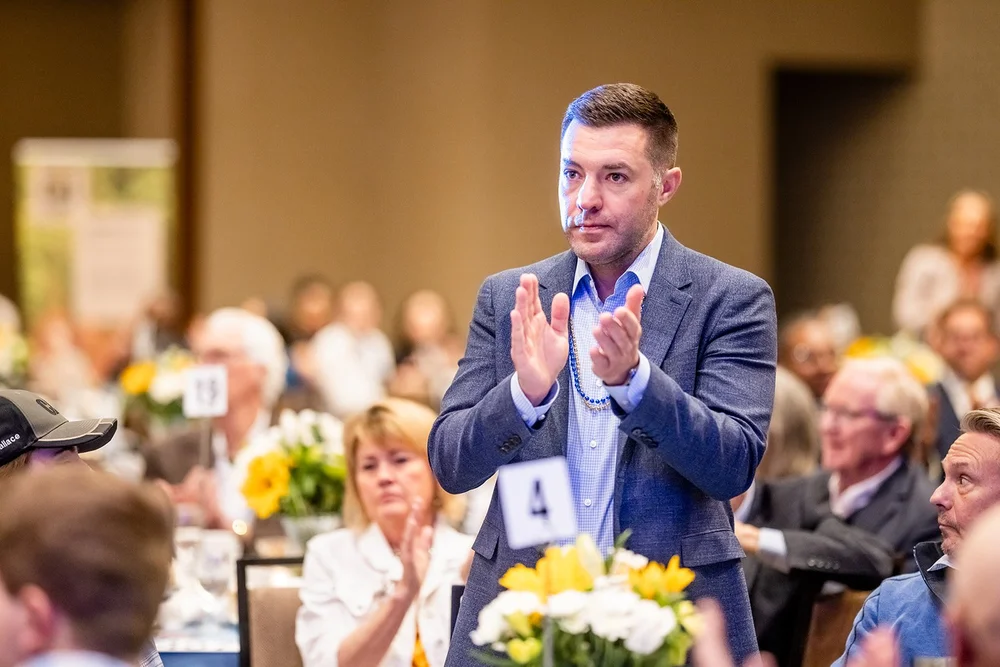 Man standing and applauding during pledge moment at CCA Annual Luncheon Hyatt Regency Aurora Colorado