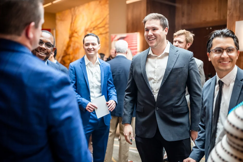 Group of young men laughing and networking at Community College of Aurora Annual Luncheon Colorado
