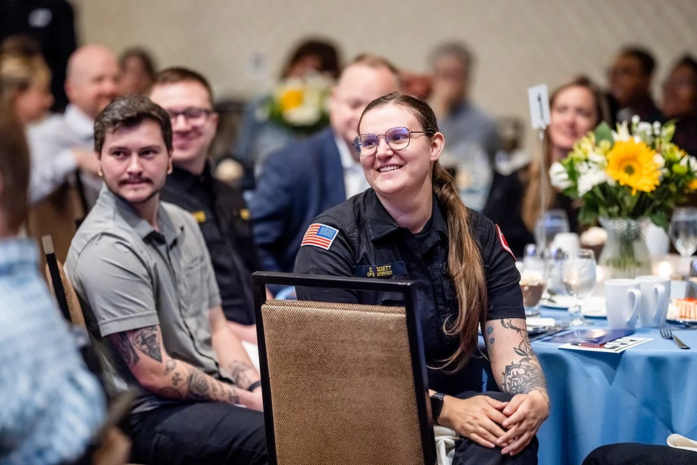 Woman in EMS uniform smiling during speaker program at CCA Annual Luncheon Hyatt Regency Aurora Colorado