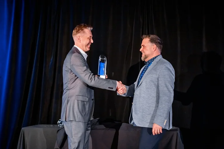 Award handshake on stage at corporate awards ceremony Englewood Colorado event photography