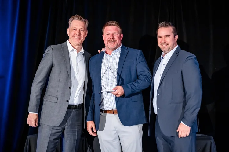 Award recipient receiving trophy on stage corporate event photography Inverness Denver