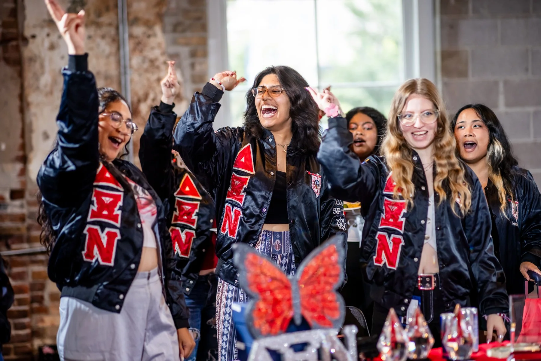Delta Zeta sorority members in matching jackets cheering at Meet the Greeks Tivoli Turnhalle Denver