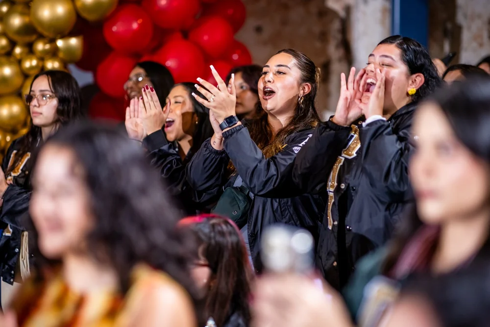 Sorority members cheering with gold and red balloon arch at Meet the Greeks MSU Denver