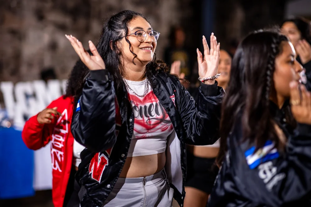 Sorority member dancing with hands raised at Meet the Greeks Tivoli Turnhalle MSU Denver