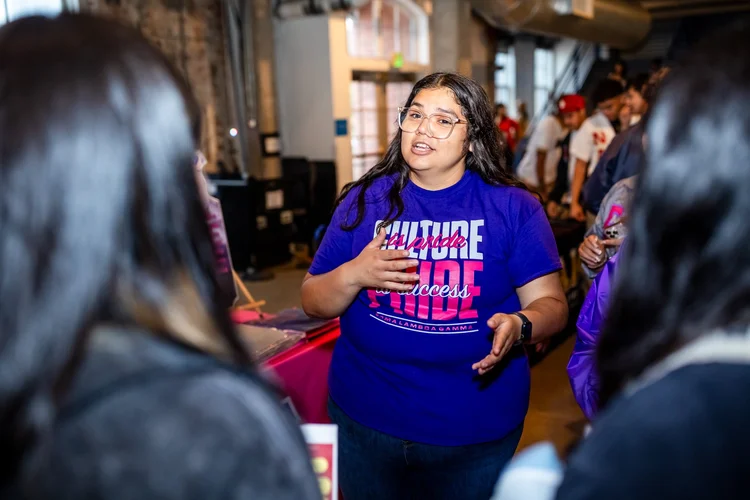 Lambda Gamma sorority member speaking to students at Meet the Greeks Tivoli Turnhalle Denver