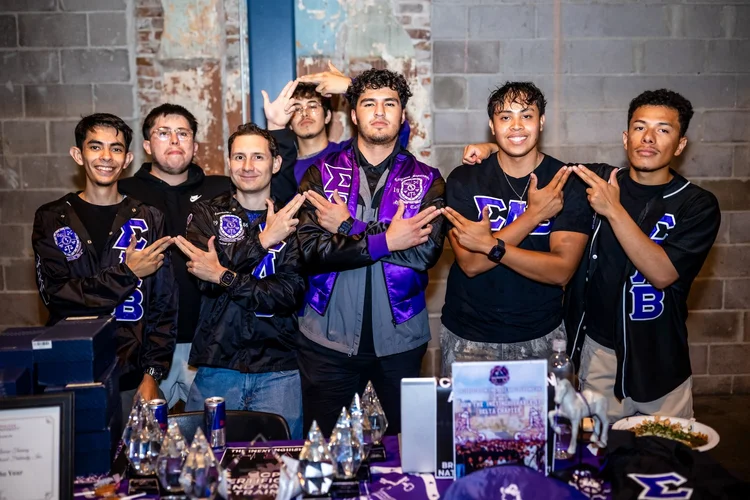 Sigma Beta fraternity members posing at recruitment table Meet the Greeks Tivoli Turnhalle Denver