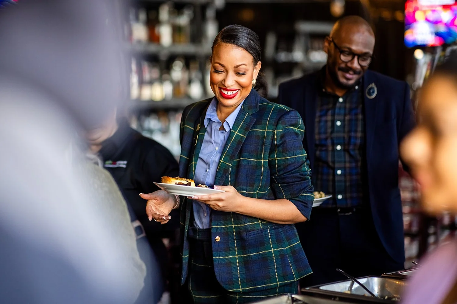 Guest in plaid blazer smiling at breakfast buffet MLK Peace Breakfast Mile High Station Denver Colorado