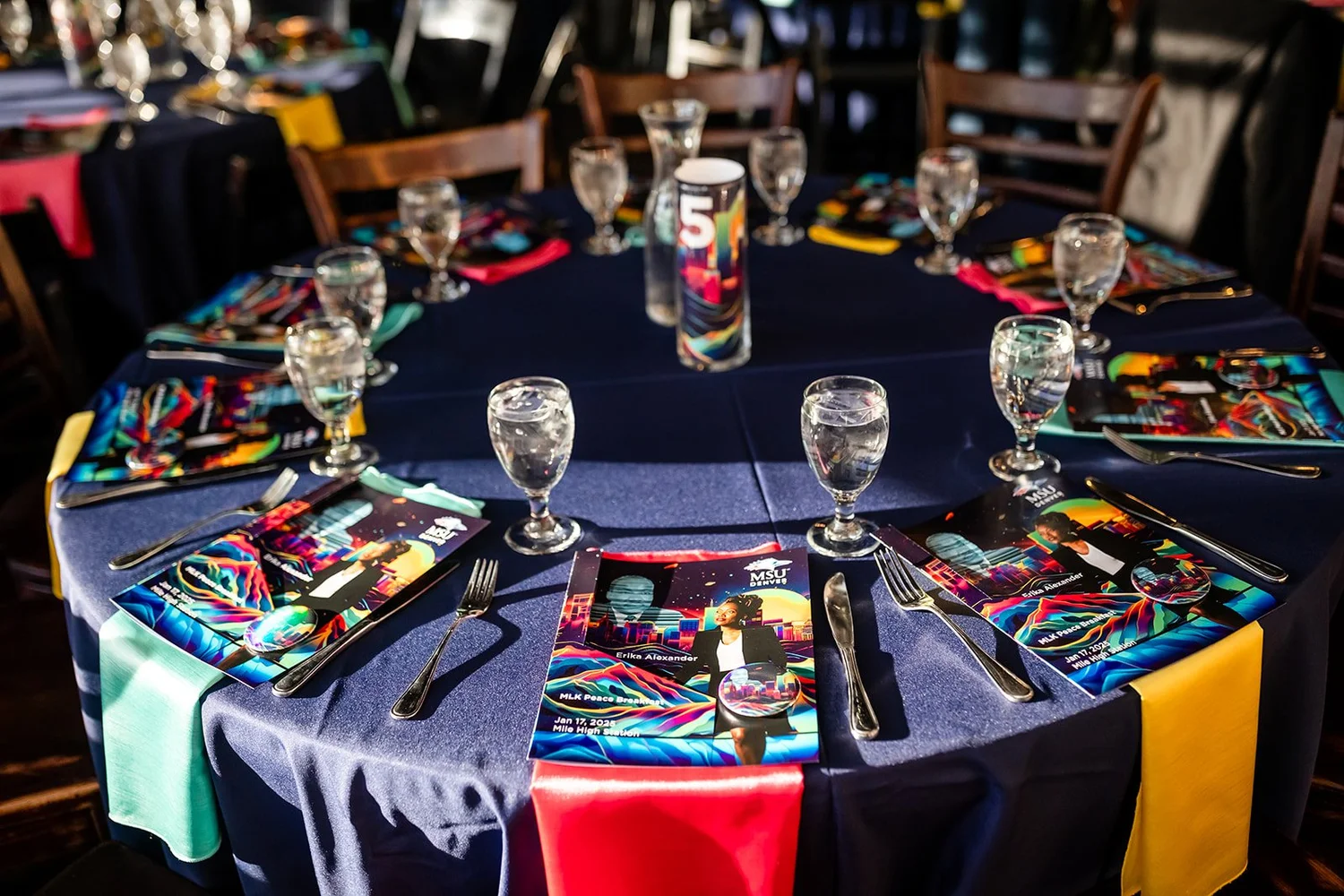 MLK Peace Breakfast table setting with programs and colorful napkins Mile High Station Denver Colorado