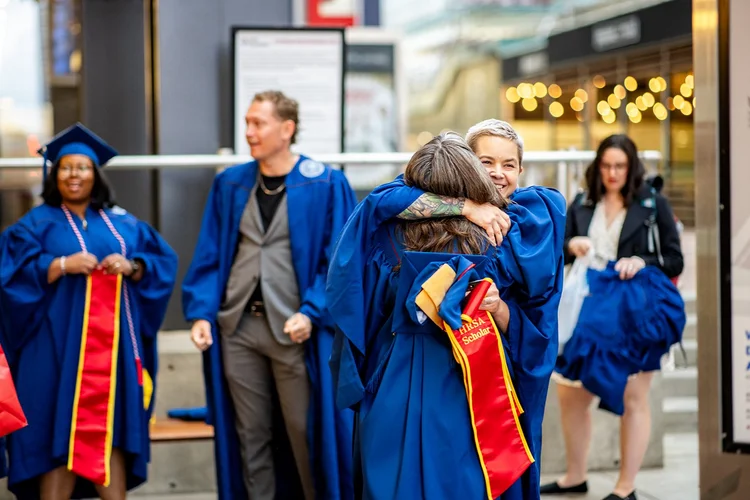 MSU Denver MSW graduate smiling with cohort member outside Denver Performing Arts Complex