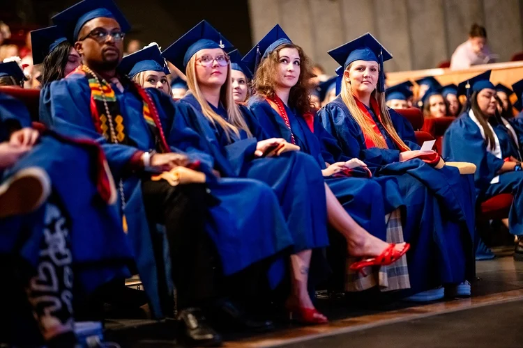 MSU Denver MSW graduates laughing and applauding seated inside Ellie Caulkins Opera House Denver