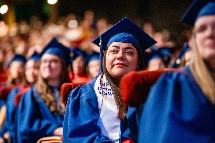 MSU Denver MSW graduate waving to family during ceremony processional Ellie Caulkins Denver