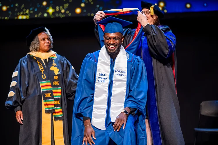 Two MSU Denver MSW graduates embracing outside Ellie Caulkins Opera House Denver Colorado