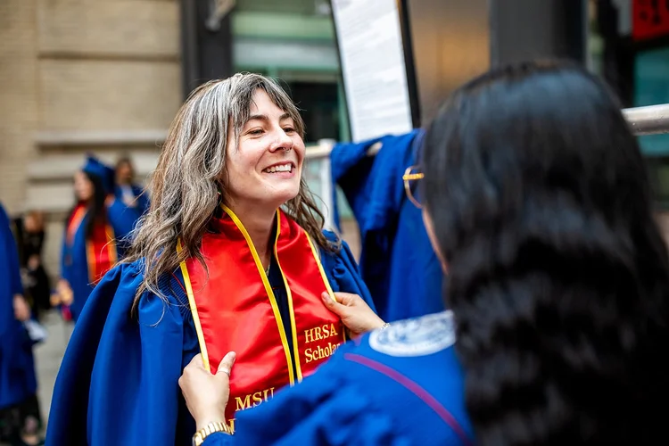 MSU Denver MSW graduate smiling during processional inside Ellie Caulkins Opera House Denver