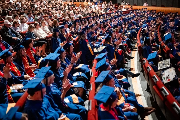 MSU Denver MSW graduate with MSW stole seated quietly during ceremony Ellie Caulkins Denver