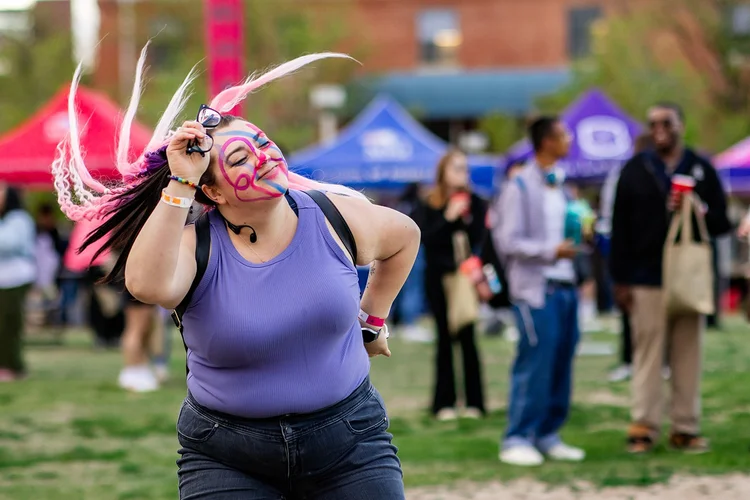 Student with face paint dancing at Roadrunners After Dark MSU Denver event
