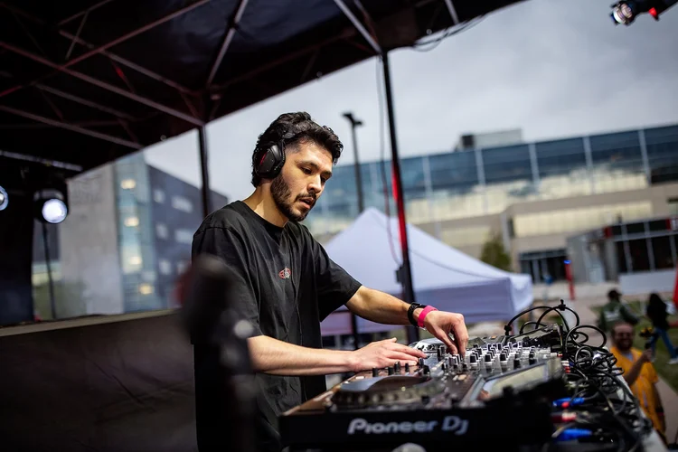 DJ at Pioneer decks on outdoor stage at Roadrunners After Dark MSU Denver