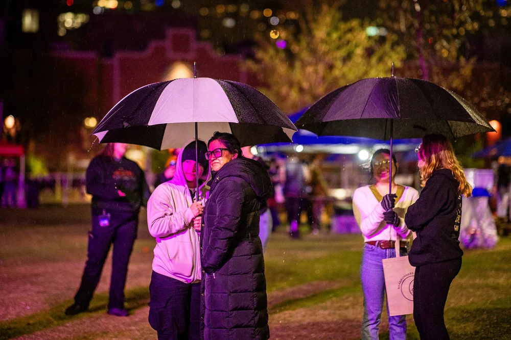 Attendees with umbrellas in rain at Roadrunners After Dark MSU Denver night event