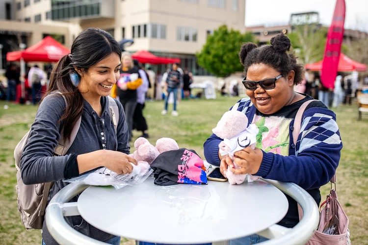 Two students laughing with stuffed animals at MSU Denver Roadrunners After Dark