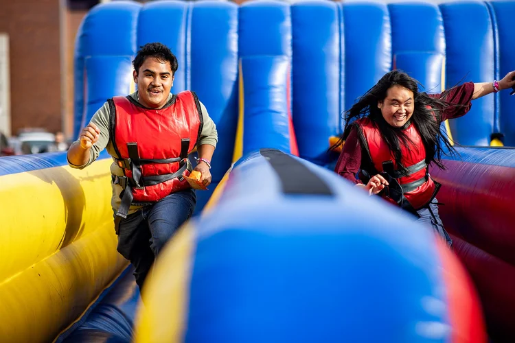 Two students racing through inflatable bungee run at MSU Denver Roadrunners After Dark